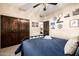 The bedroom features a decorative ceiling fan, and closet storage with wooden doors for a rustic touch at 9310 S Bala Dr, Tempe, AZ 85284