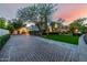 Expansive brick driveway leading to a meticulously landscaped front yard and charming home exterior at 9310 S Bala Dr, Tempe, AZ 85284