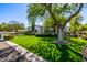 A lush front yard leads to a gorgeous home with mature trees and manicured landscaping at 9310 S Bala Dr, Tempe, AZ 85284
