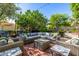 Inviting outdoor patio with wicker furniture, a fire pit and a professionally landscaped backyard with lush greenery at 9310 S Bala Dr, Tempe, AZ 85284