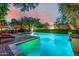 Inviting pool area with ambient lighting, lush landscaping, and brickwork offering a serene outdoor oasis at 9310 S Bala Dr, Tempe, AZ 85284