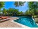 Inviting swimming pool and spa with comfortable lounge chairs set on a brick patio, surrounded by lush landscaping at 9310 S Bala Dr, Tempe, AZ 85284