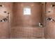 Walk-in tiled shower with mosaic tile surround, multiple shower heads, and a built-in bench offers relaxation at 9310 S Bala Dr, Tempe, AZ 85284
