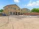 Spacious backyard with pool, covered patio, and desert landscaping with a volleyball net set up at 10010 W Illini St, Tolleson, AZ 85353
