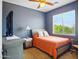 Cozy bedroom with a warm color scheme, ceiling fan, and natural light from the window at 10010 W Illini St, Tolleson, AZ 85353