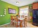 Bright dining room featuring a wooden table with seating for six, complemented by vibrant green walls at 10010 W Illini St, Tolleson, AZ 85353
