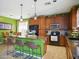Open-concept kitchen with wooden cabinetry, granite countertops, a center island, and adjacent dining area at 10010 W Illini St, Tolleson, AZ 85353