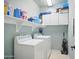 Well-equipped laundry room with washer, dryer, shelving, and cabinets for ample storage at 10010 W Illini St, Tolleson, AZ 85353