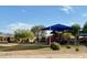 Community playground with a blue shade structure on a clear day with mountain views at 10010 W Illini St, Tolleson, AZ 85353