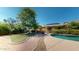 Lush backyard boasts a sparkling pool, cozy firepit, and vibrant greenery at 10440 W Swayback Pass, Peoria, AZ 85383