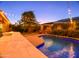 Evening shot of a backyard featuring a pool, patio, and illuminated tree at 10440 W Swayback Pass, Peoria, AZ 85383