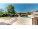 Beautiful backyard with a pool, mature tree, a cozy fire pit, and lush green artificial grass at 10440 W Swayback Pass, Peoria, AZ 85383