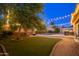 Twilight backyard with a pool, fire pit, and mature landscaping at 10440 W Swayback Pass, Peoria, AZ 85383