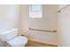 Bathroom featuring toilet with accessibility bar and a window at 10440 W Swayback Pass, Peoria, AZ 85383