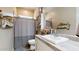 Charming bathroom with a white vanity, decorative shelves, and a shower featuring a stylish curtain at 10440 W Swayback Pass, Peoria, AZ 85383