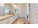Bright bathroom featuring double sinks with white cabinets and tile flooring at 10440 W Swayback Pass, Peoria, AZ 85383