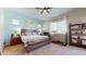 This bright bedroom includes a ceiling fan, light blue accent wall, and ample natural light at 10440 W Swayback Pass, Peoria, AZ 85383