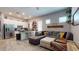 Open-concept living room showcasing a comfortable gray sectional sofa and tile flooring at 10440 W Swayback Pass, Peoria, AZ 85383