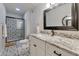 Bathroom featuring a vanity, granite countertops, a large mirror, and a walk-in shower with decorative tile at 1066 E Pueblo Rd, Phoenix, AZ 85020