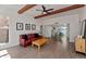 Bright living room featuring wood-look tile floors, exposed beams, and a red leather sofa at 1066 E Pueblo Rd, Phoenix, AZ 85020