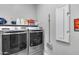 Well-equipped laundry room with gray front-load washer and dryer, and ample storage space at 1202 E Nolan Pl, Chandler, AZ 85249