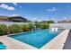 Sparkling pool area with in-water loungers and a tranquil water feature, surrounded by manicured landscaping at 1202 E Nolan Pl, Chandler, AZ 85249