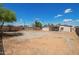 Large backyard with a mix of gravel and dirt, enclosed by a chain link fence, offering ample space for customization at 122 N 5Th St, Avondale, AZ 85323