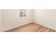 Neutral bedroom with a single window offering natural light, featuring wood-look flooring at 122 N 5Th St, Avondale, AZ 85323