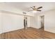 Spacious living room featuring sleek, modern wood flooring, a ceiling fan, and bright, neutral walls at 122 N 5Th St, Avondale, AZ 85323