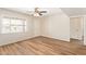 Bright living area with wood floors, a ceiling fan, and a window, enhancing natural light at 122 N 5Th St, Avondale, AZ 85323