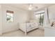 Cozy bedroom featuring neutral carpet, ceiling fan, and a bright window overlooking the neighborhood at 1350 S Greenfield Rd # 1123, Mesa, AZ 85206