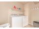 Functional laundry room with white appliances and a shelf for storage and other laundry essentials at 1350 S Greenfield Rd # 1123, Mesa, AZ 85206