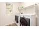 Well-lit laundry room with modern, front-loading washer and dryer and convenient overhead shelving at 1528 N Balboa --, Mesa, AZ 85205