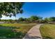 Scenic community park featuring lush green lawns, walking paths, mature trees, and shaded seating areas at 1528 N Balboa --, Mesa, AZ 85205