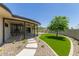 Backyard featuring artificial grass, covered patio with stone detail and stone walkway at 1545 E Christy Dr, Phoenix, AZ 85020