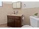 Bathroom with custom-tiled walls, vintage cabinets, sink, and toilet at 1545 E Christy Dr, Phoenix, AZ 85020