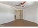 Neutral bedroom featuring a ceiling fan and closet with brown flooring and white walls at 1545 E Christy Dr, Phoenix, AZ 85020