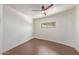 Neutral bedroom featuring a ceiling fan and window with brown flooring and white walls at 1545 E Christy Dr, Phoenix, AZ 85020