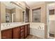 Bathroom with double sinks, soaking tub, and wood-trimmed mirror at 1612 W Lacewood Pl, Phoenix, AZ 85045