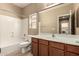 Well-lit bathroom featuring a bathtub, toilet, vanity with sink, and a large mirror that reflects the modern design at 1612 W Lacewood Pl, Phoenix, AZ 85045