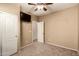 This bedroom is well-lit, featuring a TV, closet, and ceiling fan, creating a comfortable and modern space at 1612 W Lacewood Pl, Phoenix, AZ 85045