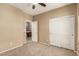 Neutral bedroom with a ceiling fan, carpet and access to an en-suite bathroom at 1612 W Lacewood Pl, Phoenix, AZ 85045