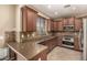 Well-lit kitchen featuring granite countertops, stainless steel appliances, and wood cabinetry at 1612 W Lacewood Pl, Phoenix, AZ 85045