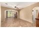 Open-concept living room featuring tile floors, arched doorways, and access to the backyard patio at 1612 W Lacewood Pl, Phoenix, AZ 85045