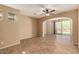 Open living room with tile floors, ceiling fan, and sliding glass doors to the backyard at 1612 W Lacewood Pl, Phoenix, AZ 85045