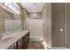 Well-lit bathroom featuring a double vanity with a shower to the right at 16525 W Tranquility Ln, Surprise, AZ 85387