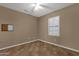 Bright, cozy bedroom with neutral walls, tiled floors, a ceiling fan, and a window fitted with plantation shutters at 16525 W Tranquility Ln, Surprise, AZ 85387