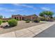 Exterior view with desert landscaping, arched entry, and well maintained lawn at 16525 W Tranquility Ln, Surprise, AZ 85387