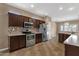 Beautiful kitchen featuring stainless steel appliances, dark wood cabinetry, tiled backsplash, and tile flooring at 16525 W Tranquility Ln, Surprise, AZ 85387