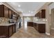 Spacious kitchen with stainless appliances, dark wood cabinetry, tiled backsplash, and views of the backyard at 16525 W Tranquility Ln, Surprise, AZ 85387